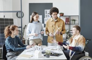 Vier Unternehmer*innen sitzen im Büro und diskutieren über Klimaschutz in ihrem Unternehmen