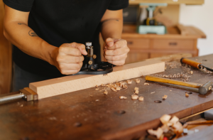 Ein Tischler arbeitet an einem Stück Holz in seiner Werkstatt.
